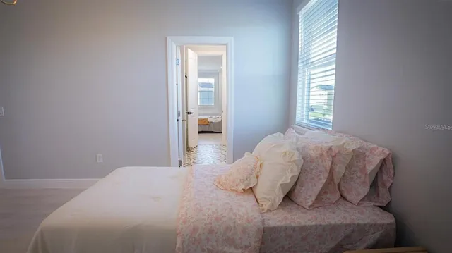 a bedroom with furniture and a large window