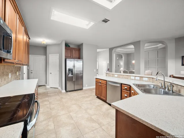 a large kitchen with kitchen island a sink stainless steel appliances and cabinets