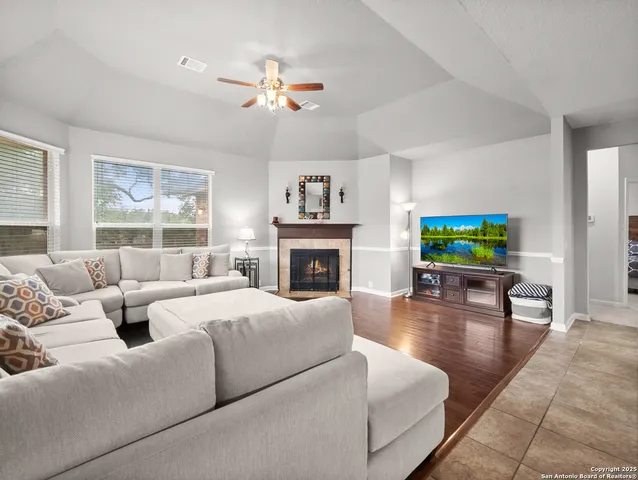 a living room with furniture a fireplace and a flat screen tv