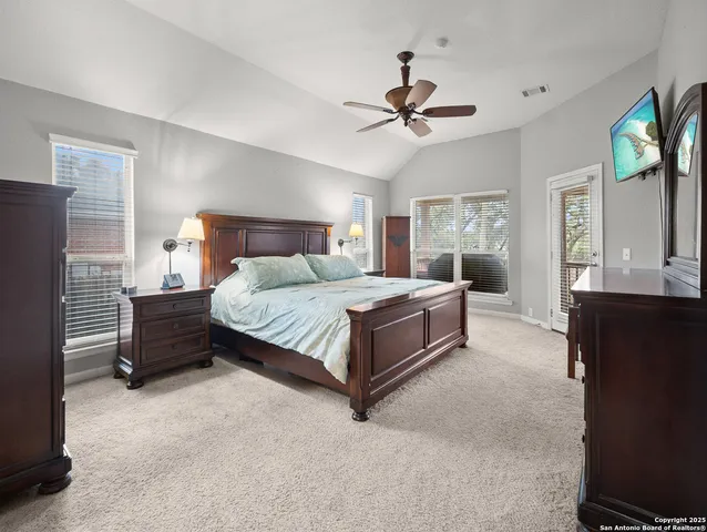a spacious bedroom with a bed and a chandelier