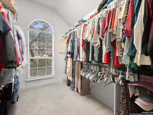 a view of walk in closet with clothes and shoes
