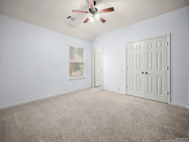 a view of an empty room with a ceiling fan
