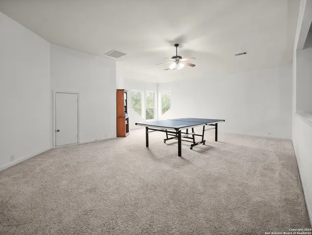 a living room with furniture and a ceiling fan