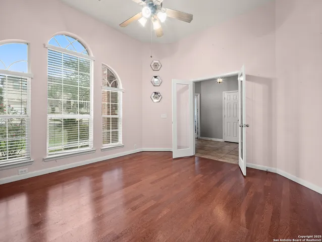a view of an empty room with wooden floor and a window