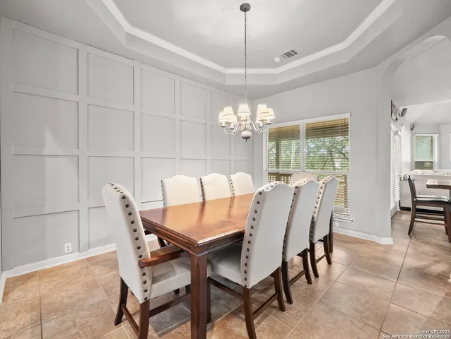 a view of a dining room with furniture and chandelier
