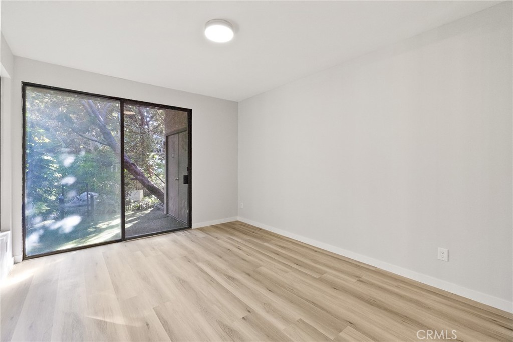 2504 West MacArthur Boulevard Santa Ana, CA 92704 - Photo 9 of 19 a view of an empty room with wooden floor and a window
