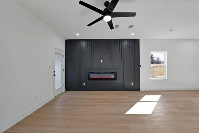 an empty room with wooden floor and windows