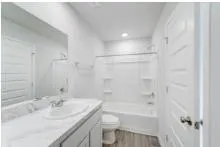 a bathroom with a granite countertop sink a toilet and shower