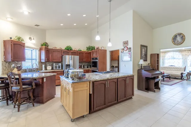 a kitchen with stainless steel appliances granite countertop a stove refrigerator and cabinets