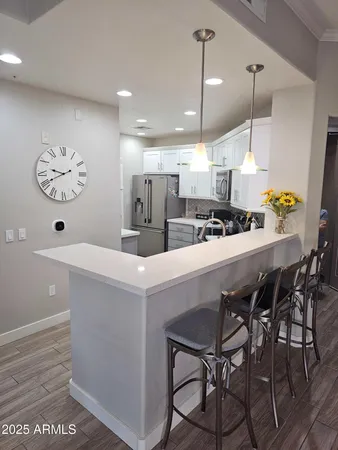 a kitchen with stainless steel appliances a table chairs and a chandelier