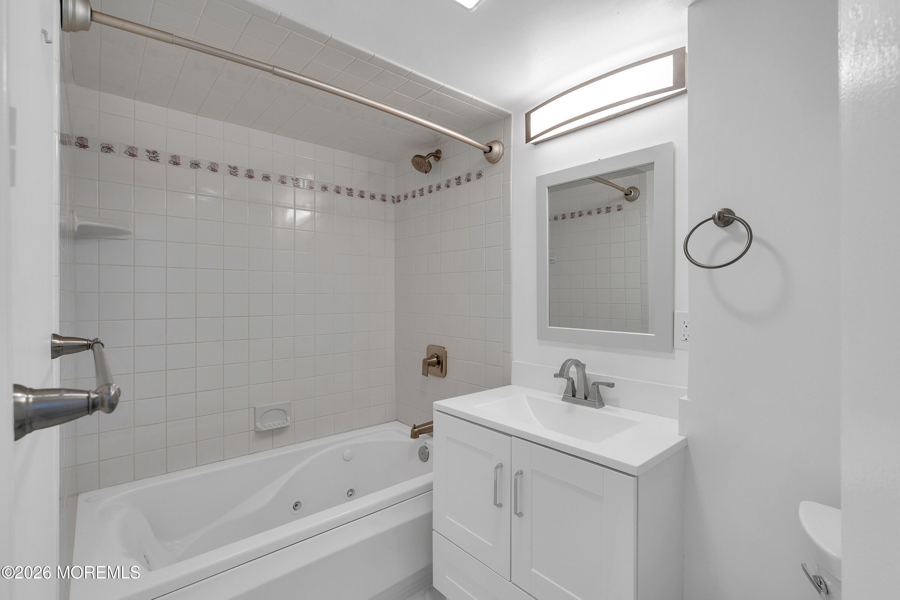 15 Wyckham Road Spring Lake Heights, NJ 07762 - Photo 26 of 38 a bathroom with a bathtub shower sink vanity and a mirror