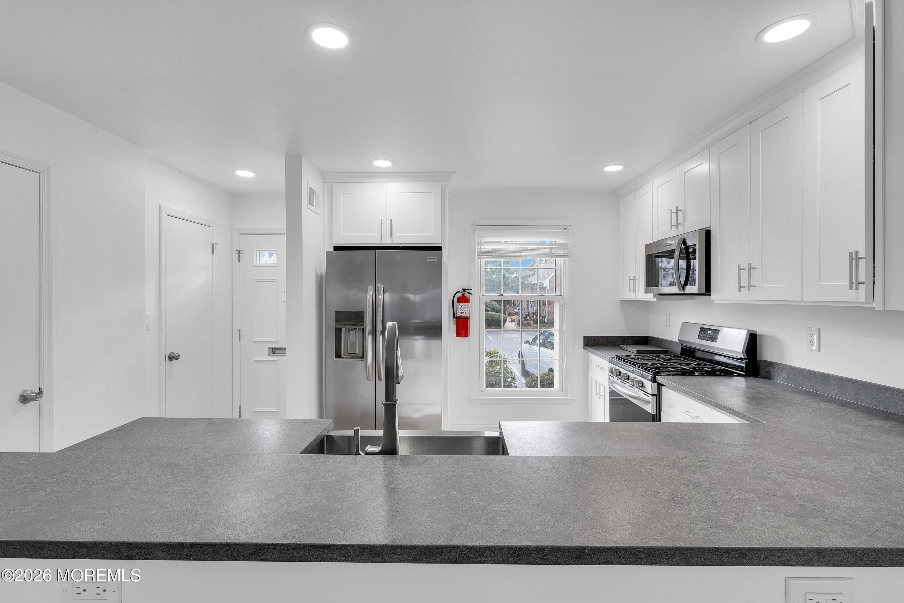 15 Wyckham Road Spring Lake Heights, NJ 07762 - Photo 10 of 38 a kitchen with stainless steel appliances kitchen island granite countertop a refrigerator and a sink