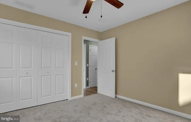 an empty room with chandelier fan