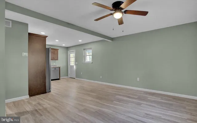 an empty room with wooden floor a ceiling fan and closet