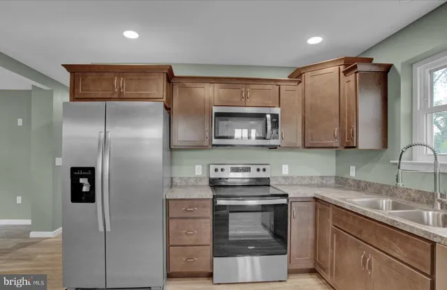 a kitchen with a refrigerator sink and cabinets