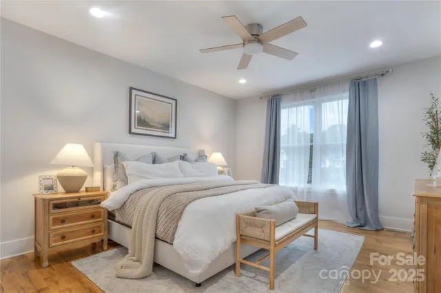 a spacious bedroom with a bed a couch and a chandelier