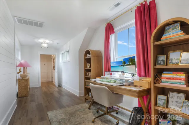 a view of a workspace with furniture and a window