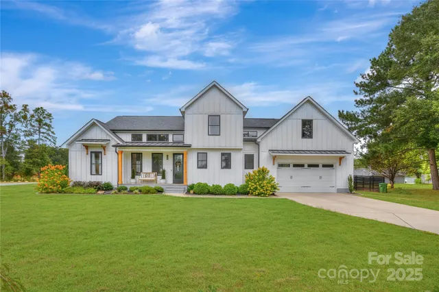 a aerial view of a house with a garden and lake view