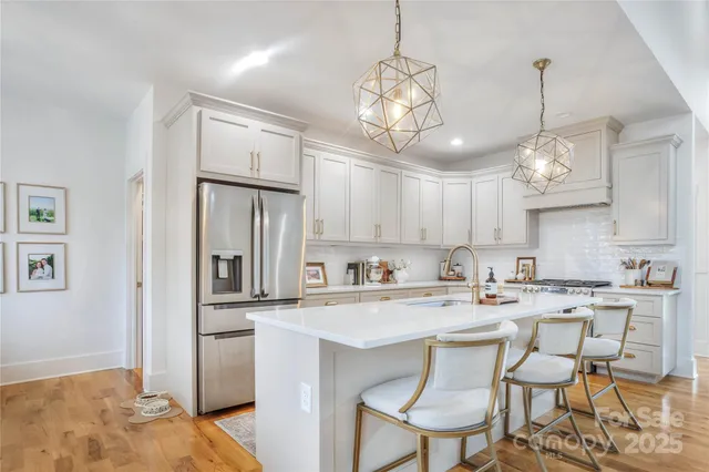 a kitchen with stainless steel appliances a table and chairs in it