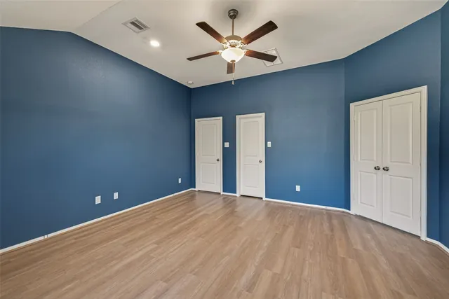 a bedroom with a large bed and a chandelier fan