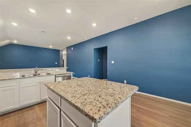 a kitchen with granite countertop a sink stove and microwave
