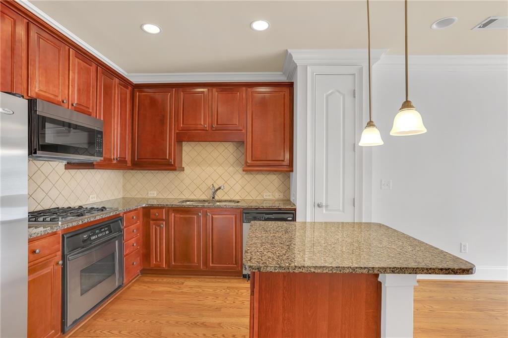 2300 Peachford Road, Unit 1209 Atlanta, GA 30338 - Photo 5 of 31 a kitchen with stainless steel appliances granite countertop a sink a stove and a microwave