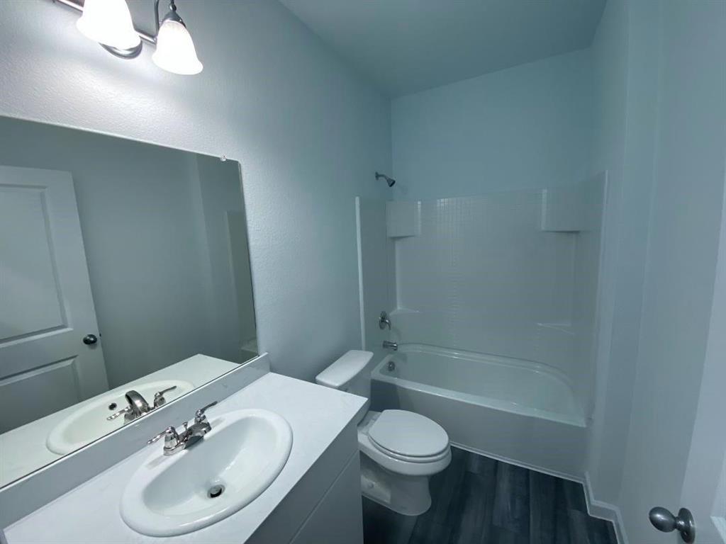 623 Colgate Circle Princeton, TX 75407 - Photo 14 of 15 Bathroom featuring a white vanity with an integrated sink, polished chrome faucet, a large wall-mounted mirror, and a two-light vanity fixture
