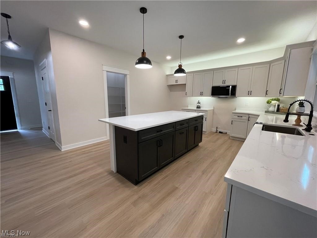 7374 Crossfield Road Mentor, OH 44060 - Photo 17 of 35 Kitchen with white cabinetry, an island, light countertops, hanging light fixtures, walk-in pantry and light flooring