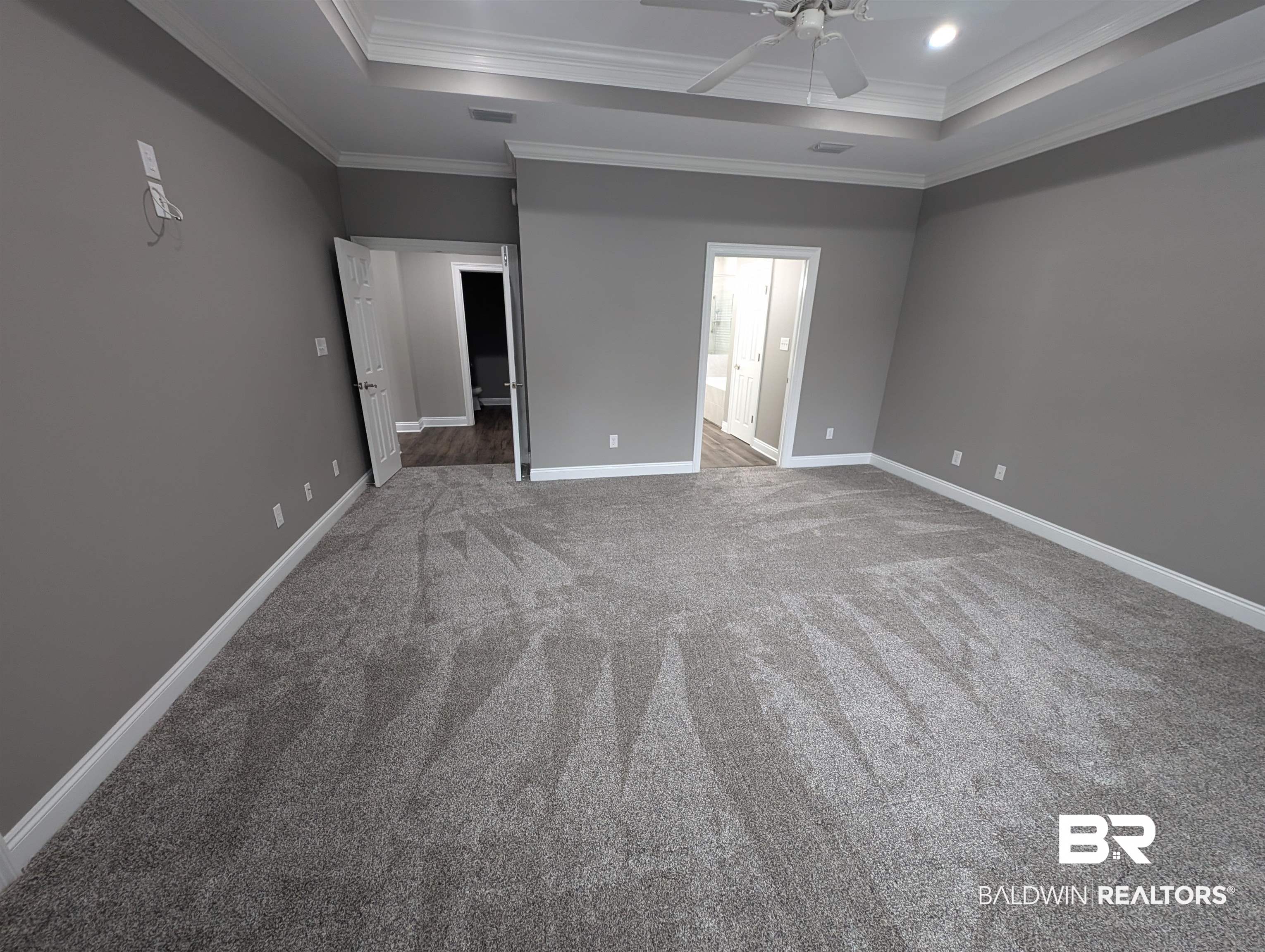 11623 Halcyon Loop Daphne, AL 36526 - Photo 57 of 90 Unfurnished primary owners bedroom with ceiling fan, carpet floors, a tray ceiling, ensuite, and crown molding