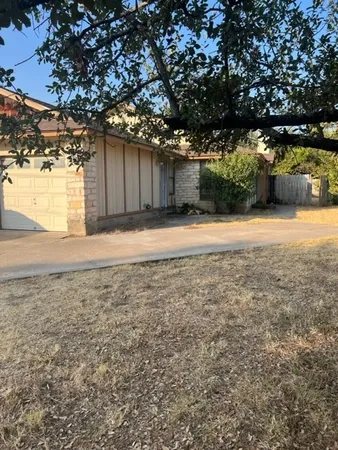 a backyard of a house with a stove and large tree