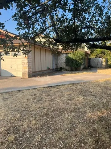 a backyard of a house with a stove and large tree
