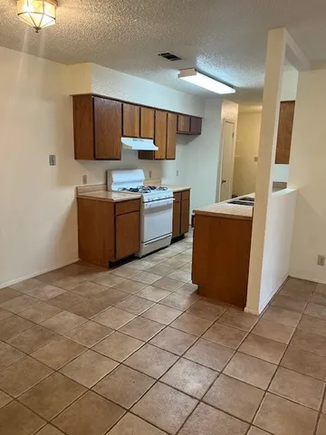 a kitchen with stainless steel appliances a stove a sink a refrigerator a microwave and cabinets