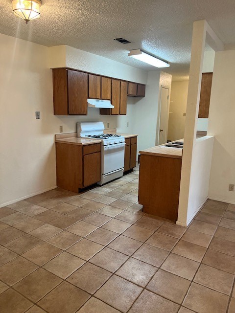 112 Verna Spur, Unit B Georgetown, TX 78628 - Photo 6 of 23 a kitchen with stainless steel appliances a stove a sink a refrigerator a microwave and cabinets