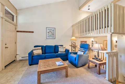 a living room with furniture a rug and a window