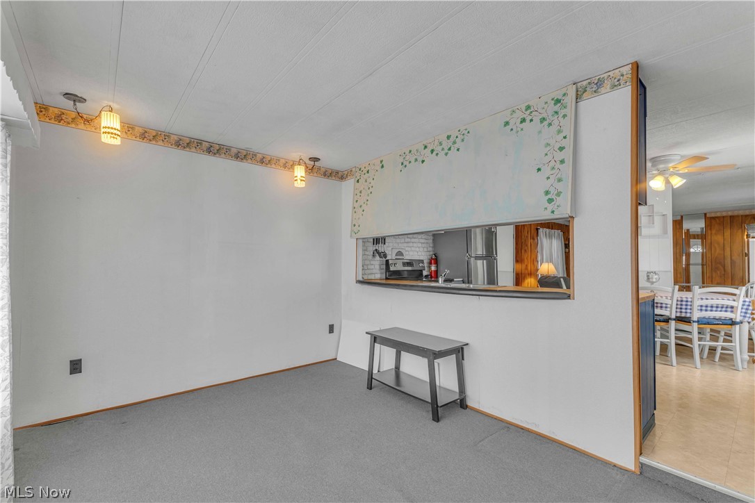 6610 Lear Nagle Road, Unit 154 North Ridgeville, OH 44039 - Photo 7 of 26 Unfurnished living room with carpet flooring and a ceiling fan