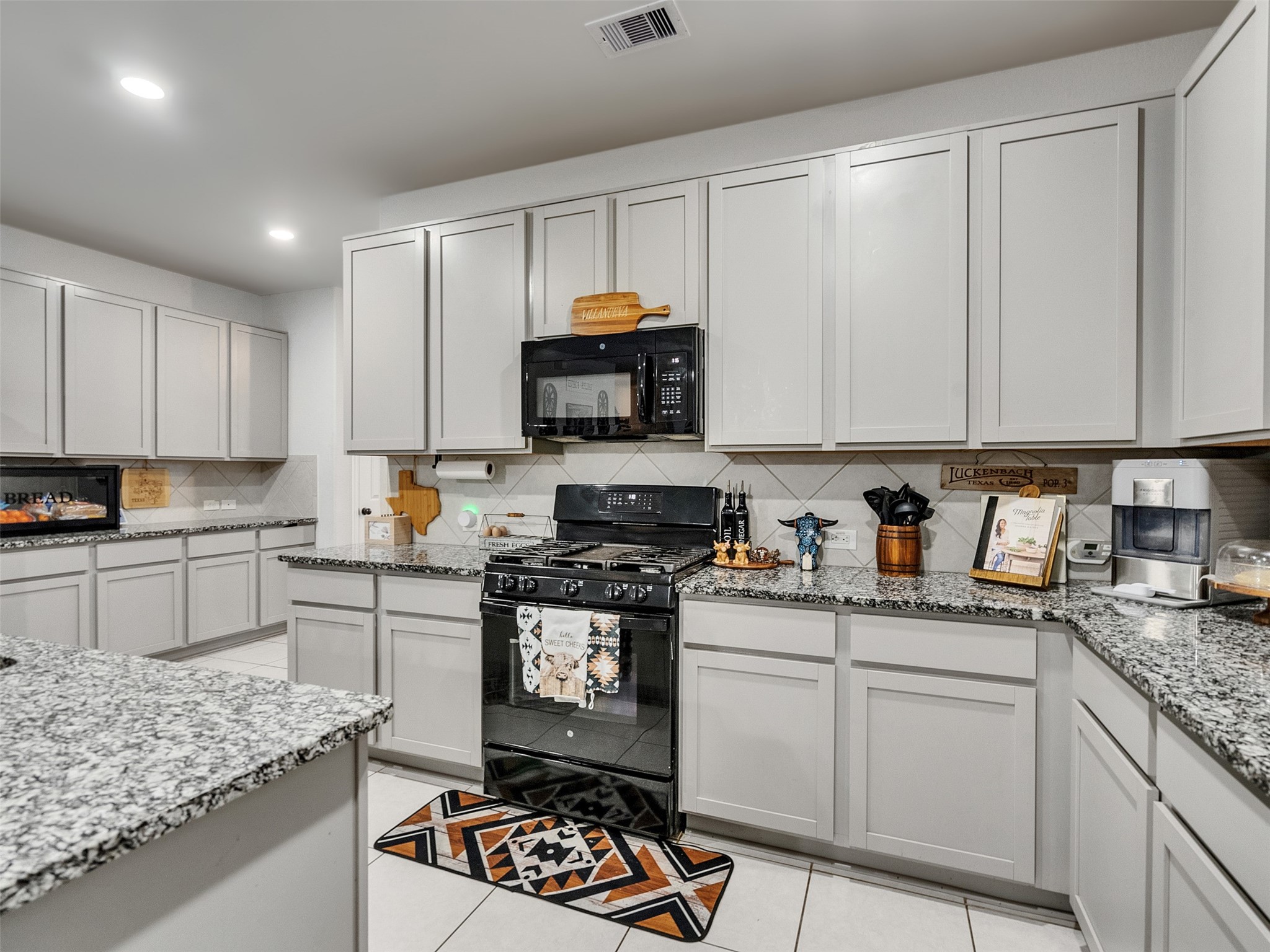 8719 Willet Street Baytown, TX 77521 - Photo 28 of 42 a kitchen with granite countertop a stove sink and cabinets