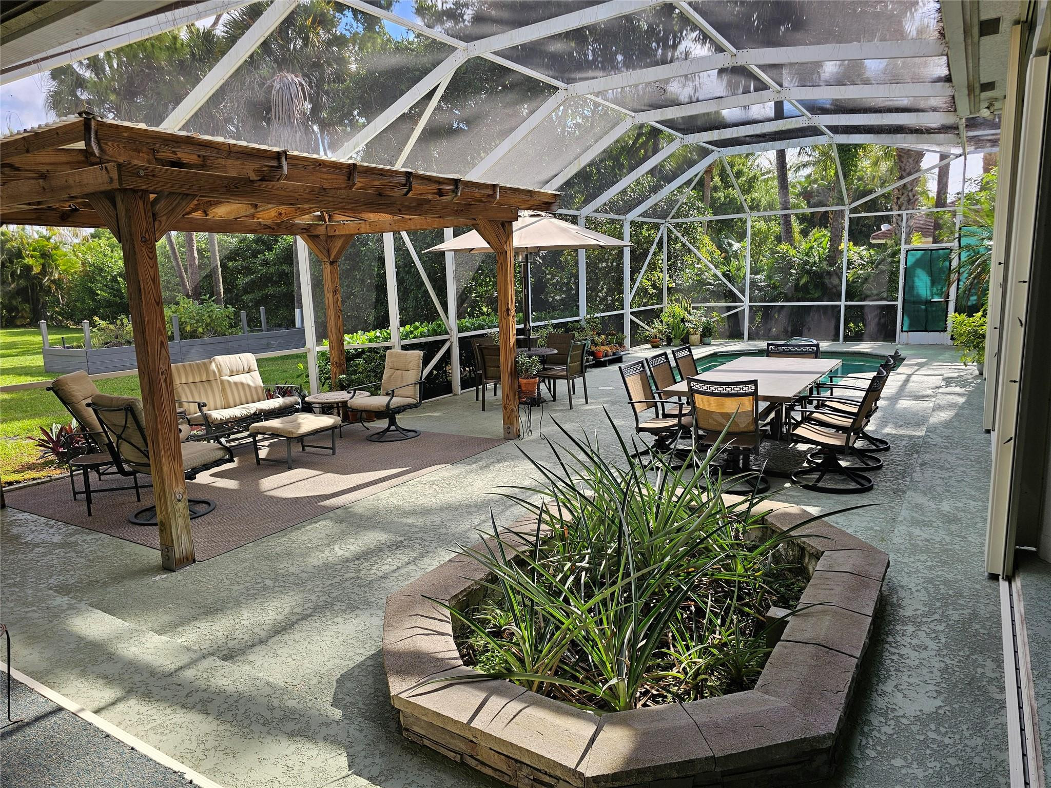6963 Wilson Road West Palm Beach, FL 33413 - Photo 24 of 29 a view of a patio with table and chairs potted plants and floor to ceiling window