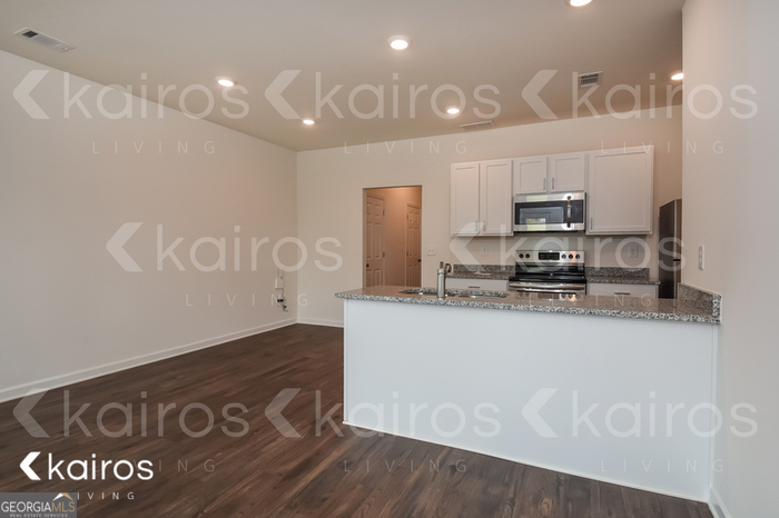 123 Dudley Way Cartersville, GA 30120 - Photo 4 of 16 a kitchen with kitchen island granite countertop a sink a stove a refrigerator and a granite counter tops