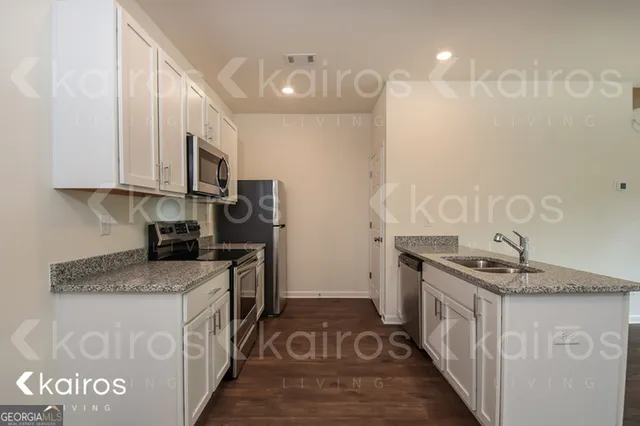 a kitchen with stainless steel appliances granite countertop a sink stove and refrigerator