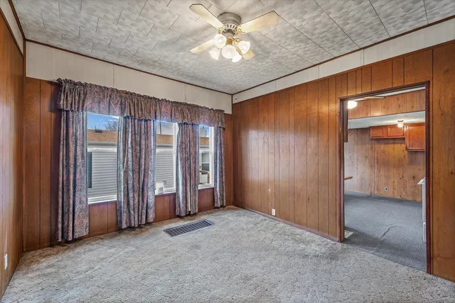 an empty room with closet and a ceiling fan