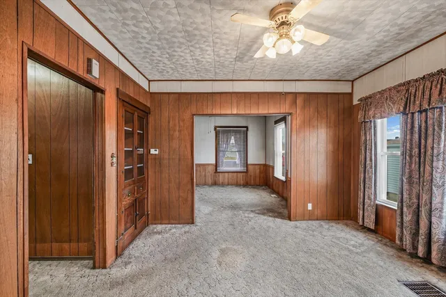 an empty room with closet and a chandelier fan