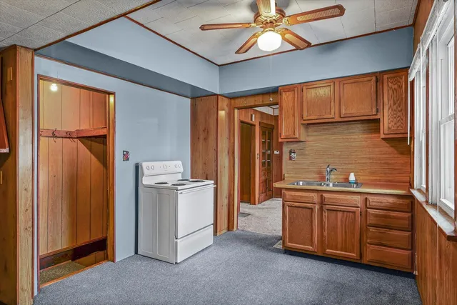 a kitchen that has a lot of cabinets stainless steel appliances and a window