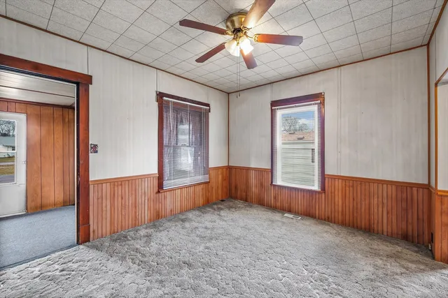 an empty room with windows and fan