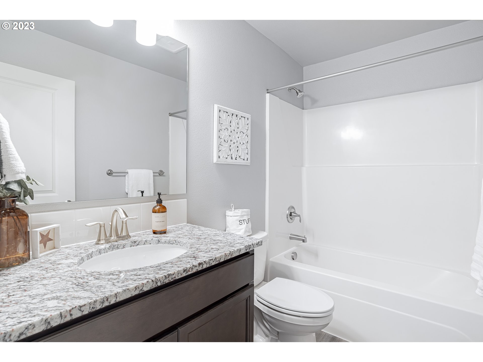 501 Hooper Road Longview, WA 98632 - Photo 14 of 28 a bathroom with a granite countertop sink a toilet a mirror and shower