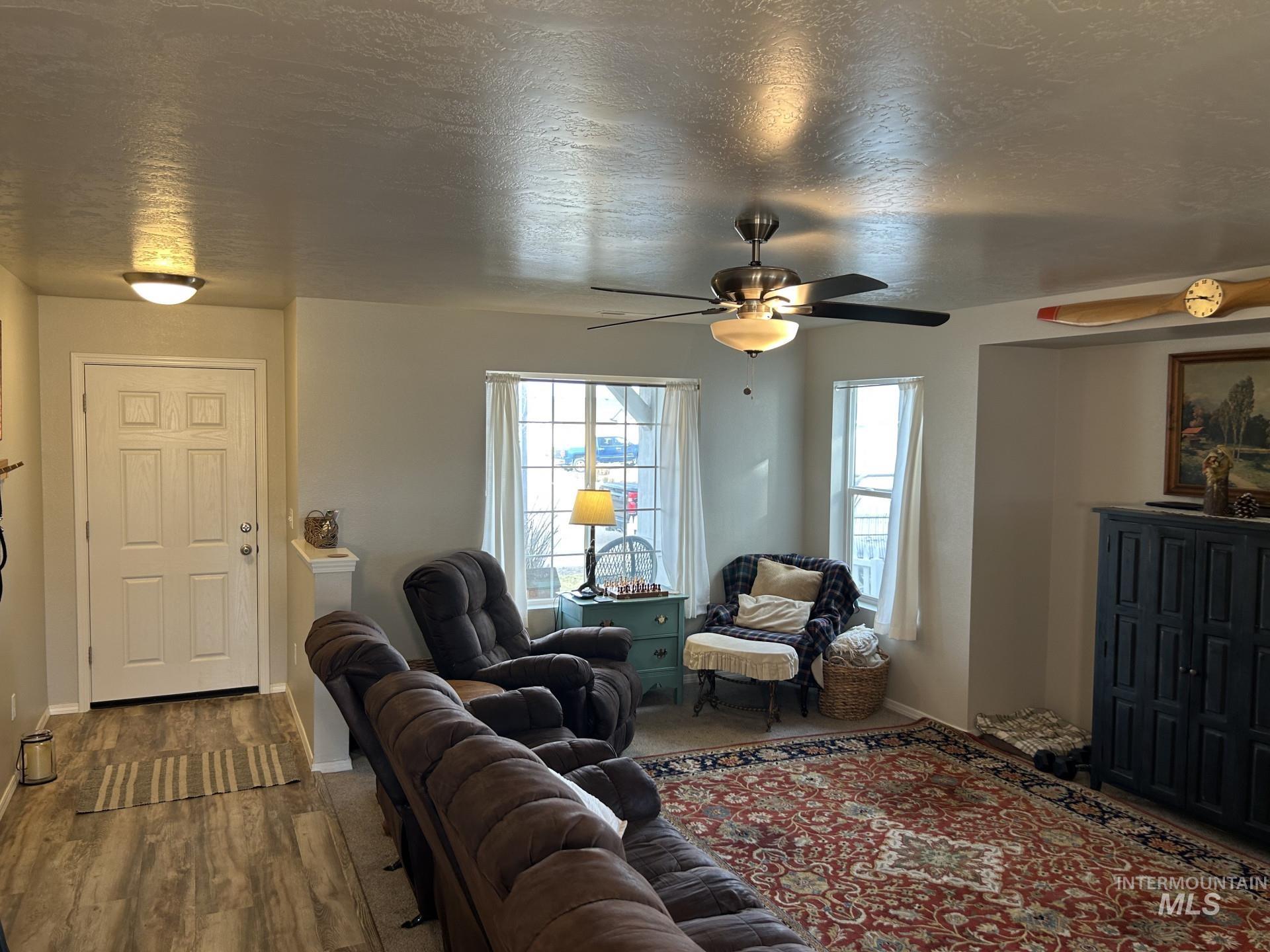 5614 Barkley Way Caldwell, ID 83607 - Photo 13 of 50 Living room with a textured ceiling, dark wood finished floors, and a ceiling fan