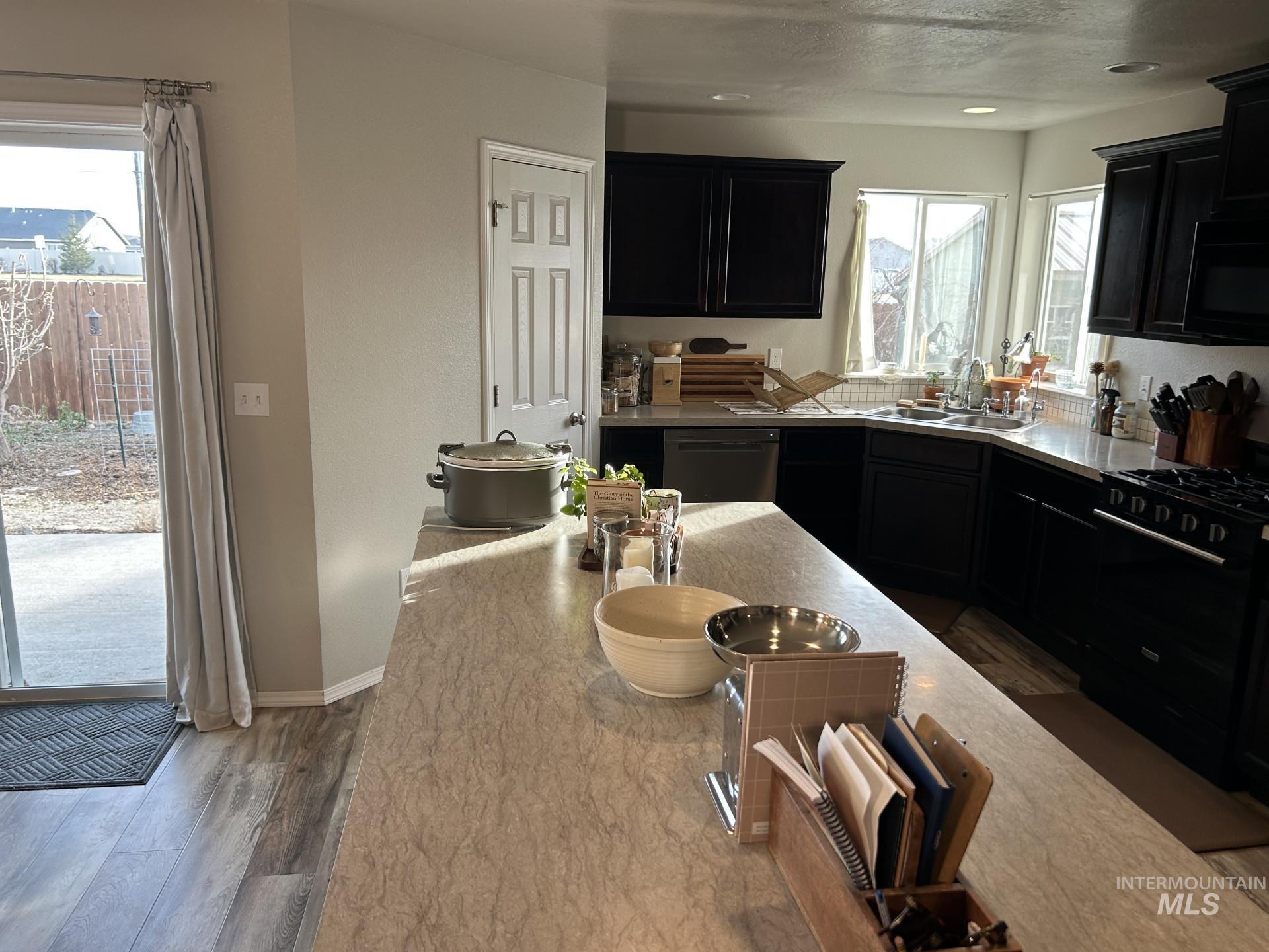 5614 Barkley Way Caldwell, ID 83607 - Photo 17 of 50 Kitchen with dark cabinets, black appliances, and healthy amount of natural light