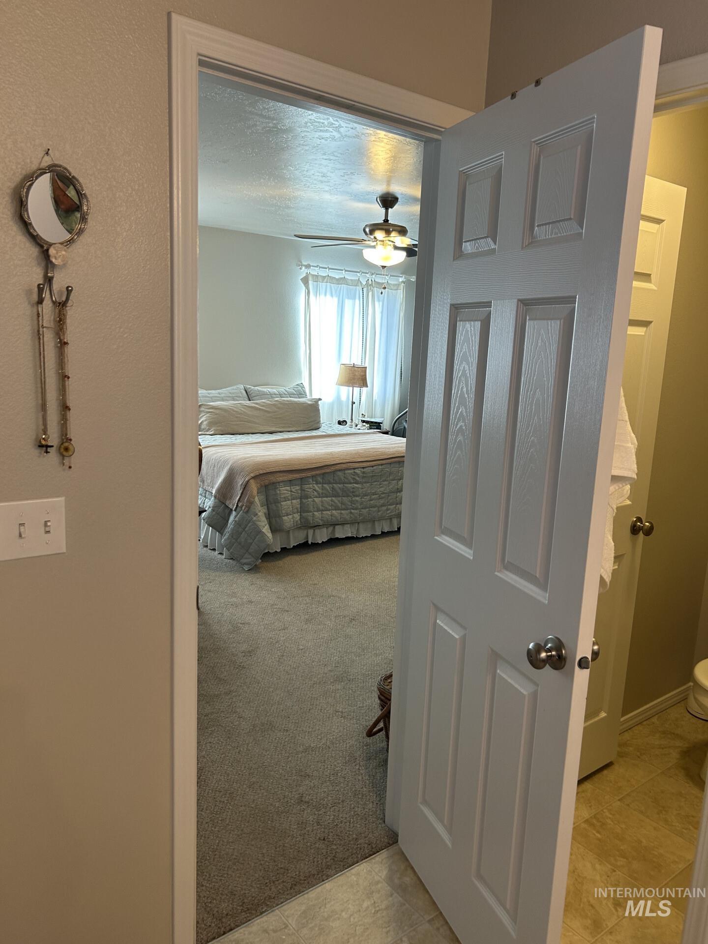5614 Barkley Way Caldwell, ID 83607 - Photo 39 of 50 Bedroom with light carpet, ceiling fan, and ensuite bathroom