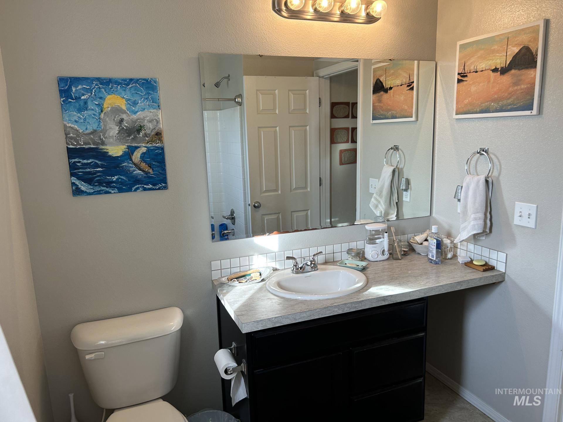 5614 Barkley Way Caldwell, ID 83607 - Photo 47 of 50 Bathroom with vanity, a textured wall, tasteful backsplash, and tub / shower combination