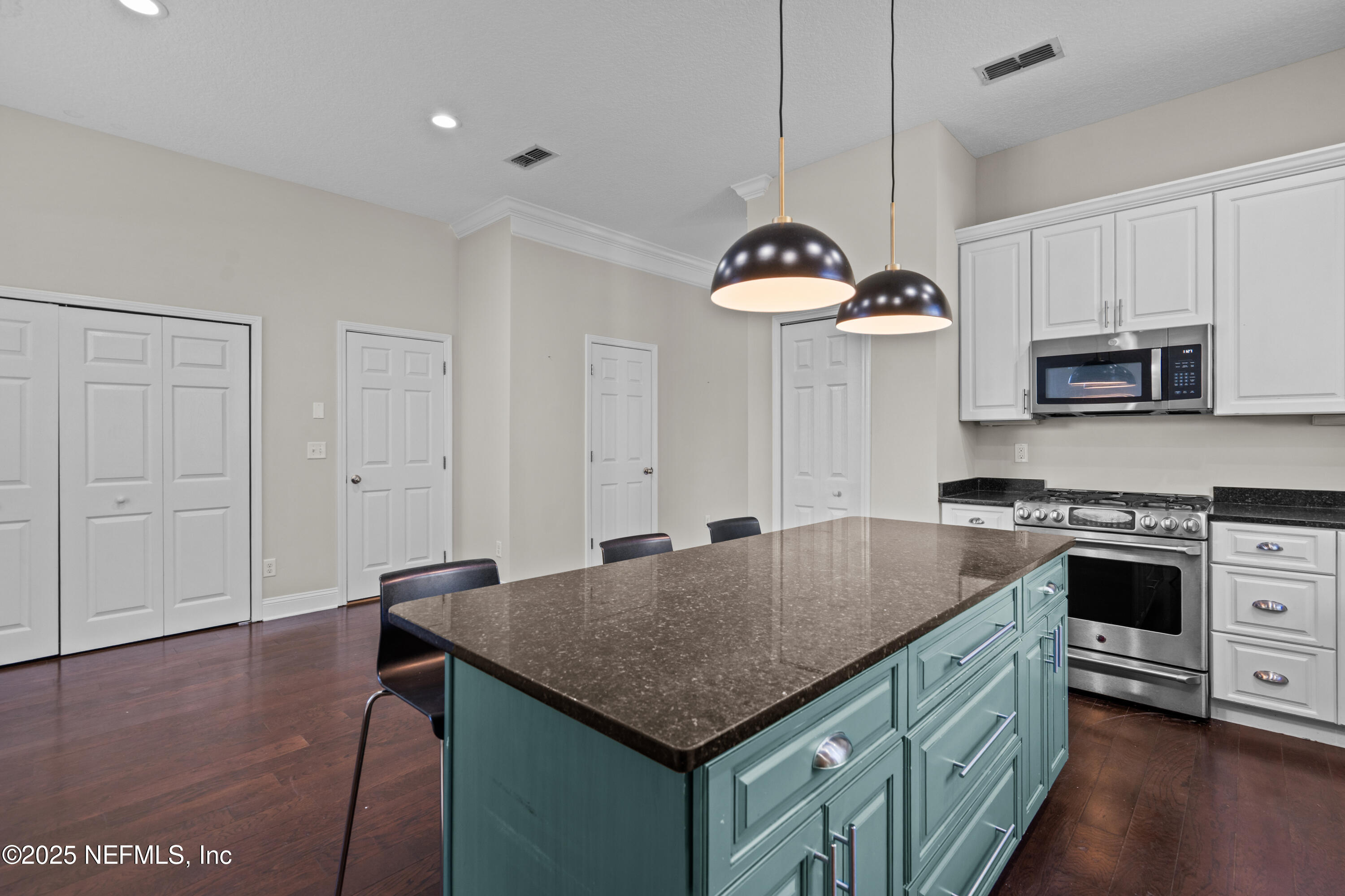 4187 Quail Drive St. Augustine, FL 32084 - Photo 12 of 38 a kitchen with kitchen island granite countertop a table chairs stove and microwave