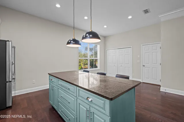 a kitchen with granite countertop a sink cabinets and wooden floor